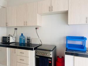 a kitchen with white cabinets and a black counter top at Adjana’s Cozy apartment in Nairobi