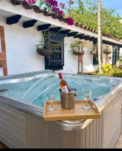 uma banheira de hidromassagem com uma garrafa de vinho e 2 copos em Hotel Villa María Santa Fe de Antioquia em Santa Fe de Antioquia