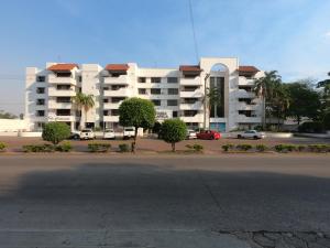 a large apartment building with cars parked in a parking lot at Suite 5 Estrellas in Santa Cruz de la Sierra