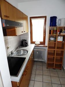 eine kleine Küche mit einem Waschbecken und einem Fenster in der Unterkunft Appartement Zeitz Ramsau in Ramsau bei Berchtesgaden