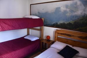 two bunk beds in a room with a painting on the wall at La Cigarra Casa de Huéspedes in Salento
