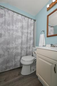 ein Badezimmer mit einem WC, einem Waschbecken und einem Spiegel in der Unterkunft Recharge and Reconnect Your cozy Vermilion nest in Vermilion