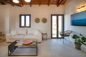 a living room with a couch and a tv at Stoupa Harmony Suites - Two Bedroom Apartment in Stoupa