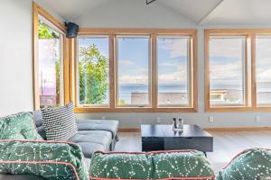 een woonkamer met een bank, een tafel en ramen bij Pacific View Home in Seattle