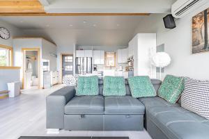 een woonkamer met een grijze bank en een keuken bij Pacific View Home in Seattle