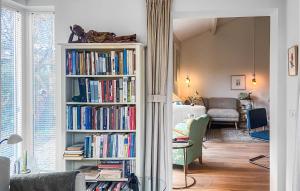ein Wohnzimmer mit einem Bücherregal voller Bücher in der Unterkunft Nice Home In Egmond Aan Den Hoef With Kitchen in Egmond aan den Hoef