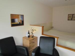 ベルゲンにあるAppartementen Huize Eikenhofのベッドルーム(椅子2脚、ベッド1台付)