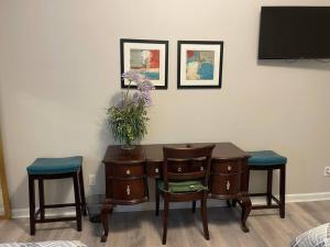 a desk with two chairs and a vase with flowers on it at Adorable Apt with Access to Pool and Tennis Courts in Dallas