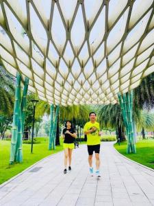 a man and woman walking under a pavilion in a park at The Origami: Exclusive Living ! in Long Bình