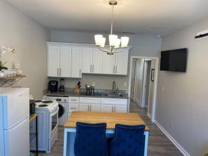 a kitchen with white cabinets and a wooden table at Adorable Apt with Access to Pool and Tennis Courts in Dallas
