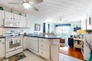 a kitchen with white cabinets and a counter top at Captain's Villa 9-C Sunshine Ally in Holden Beach