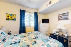 a bedroom with a bed and a window at Captain's Villa 9-C Sunshine Ally in Holden Beach
