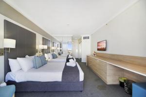 a hotel room with two beds and a television at Ocean View Studio with Rooftop Jacuzzi in Gold Coast