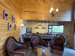 soggiorno con sedie in pelle e bar di Providencia PREMIUM Cabañas del Lago - Luciérnaga a Los Alamillos