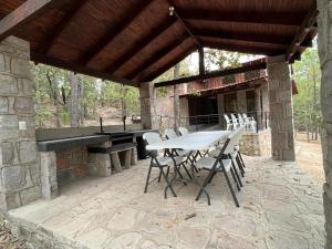 un patio con tavolo, sedie e pianoforte di Providencia PREMIUM Cabañas del Lago - Luciérnaga a Los Alamillos