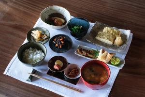 eine Gruppe von Schüsseln mit Lebensmitteln auf einem Tisch in der Unterkunft 福田屋 in Imazu