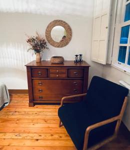 Zimmer mit einer Kommode mit einem Spiegel und einem Stuhl in der Unterkunft La Casa de María Pita in A Coruña