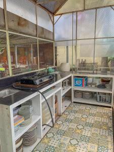 a kitchen with a counter with plates and dishes at Carla Garden Villa in Yogyakarta