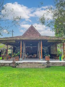 a pavilion with chairs and tables in a park at Carla Garden Villa in Yogyakarta