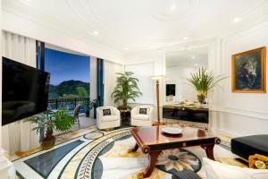 ゴールドコーストにあるImperial Hotel Gold Coastのリビングルーム(テレビ、ソファ、テーブル付)