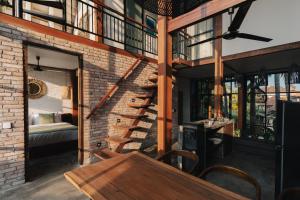 a room with a brick wall and a spiral staircase at Sanctuary Villas in Ubud