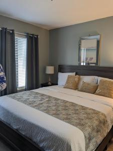 1 dormitorio con 1 cama grande y espejo en Blissful en Hilton Head Island