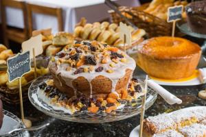 Una mesa con un pastel en un plato con otros pasteles. en Hotel Serra Everest, en Nova Friburgo