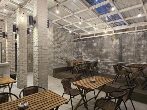 an empty restaurant with wooden tables and chairs at The Freedom Club Hostel KL in Kuala Lumpur