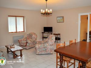a living room with a table and chairs and a dining room at Longère authentique avec jardin privé, près des Châteaux de la Loire, idéale pour familles et nature - FR-1-381-501 in Saint-Laurent-de-Lin