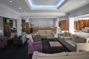 a living room with couches and chairs and a table at The Collection Hotel Birmingham in Birmingham