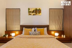 Un dormitorio con una cama grande con dos ventanas. en Eden's Estate by StayVista - Featuring cozy rooms with a private pool, and modern interiors for a delightful stay, en Alibaug