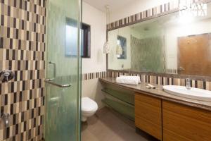 Un baño con lavabo, inodoro y espejo. en Eden's Estate by StayVista - Featuring cozy rooms with a private pool, and modern interiors for a delightful stay, en Alibaug 14 fotos más
