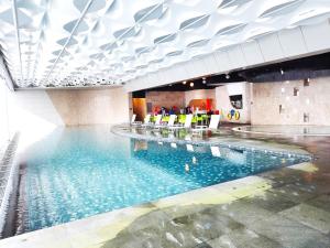- une grande piscine avec des chaises dans un bâtiment dans l'établissement GentingTop CozyColdSuite4Pax at GrdIonDelmn, à Genting Highlands