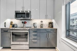 cocina con electrodomésticos de acero inoxidable y microondas en Waterfront Two Bedroom apartment in a brand new building apts, en Washington
