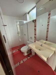 een badkamer met een witte wastafel en een toilet bij Recreo Beach in Huanchaco
