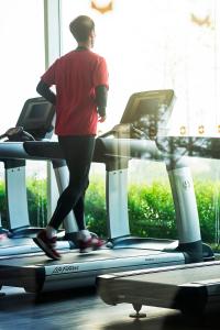 une personne marchant sur un tapis de course dans une salle de sport dans l'établissement Shangri-La Qinhuangdao, à Qinhuangdao