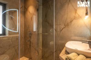 y baño con ducha y lavamanos. en StayVista's Vogue Vista - Contemporary Chic Interiors, Terrace & Indoor-Outdoor Games, en Calcuta