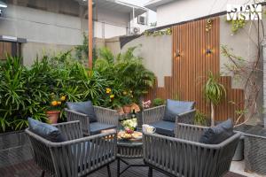 un patio con sillas, mesa y plantas en StayVista's Vogue Vista - Contemporary Chic Interiors, Terrace & Indoor-Outdoor Games, en Calcuta
