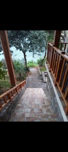 une passerelle en briques avec une balustrade en bois et des arbres dans l'établissement CASA TRIBU, à San Antonio Palopó