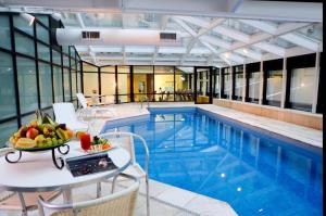 a pool with a table with a bowl of fruit on it at Flat SP no Hotel Wyndham Ibirapuera - Moema in Sao Paulo