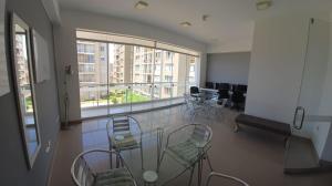 a room with a table and chairs and a large window at HERMOSO DEPARTAMENTO-DUPLEX CON VISTA DE CHICLAYO in Chiclayo