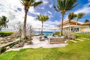 un patio trasero con palmeras y una casa en Cacique Casa De Campo, en La Romana