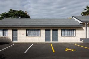 un bâtiment avec des fenêtres et un parking dans l'établissement BK's Pohutukawa Lodge, à Whangarei