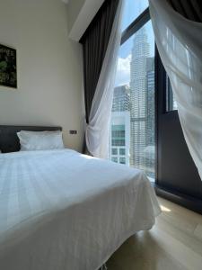 een slaapkamer met een wit bed en een groot raam bij Premium Getaways in Kuala Lumpur
