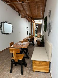 una sala da pranzo con tavolo, panche e TV di B&B CALLE REAL a San Roque