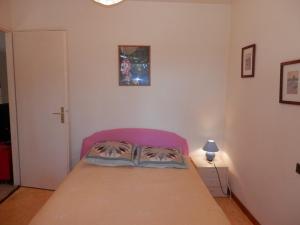 a small bedroom with a bed with a pink head board at Maisonnette 3 chambres proche Océan - Animaux admis - FR-1-379-145 in Messanges