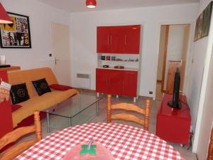 a living room with red cabinets and a table at Maisonnette 3 chambres proche Océan - Animaux admis - FR-1-379-145 in Messanges +4 photos