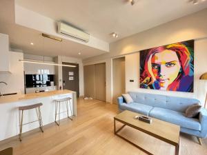 een woonkamer met een blauwe bank en een keuken bij Premium Getaways in Kuala Lumpur