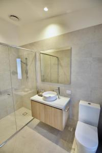 a bathroom with a toilet and a sink and a shower at Hamilton By the Bay 3 Newly Built in Safety Beach