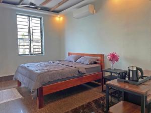 1 dormitorio con 1 cama y 1 mesa en Garden Riverside, en Kampot